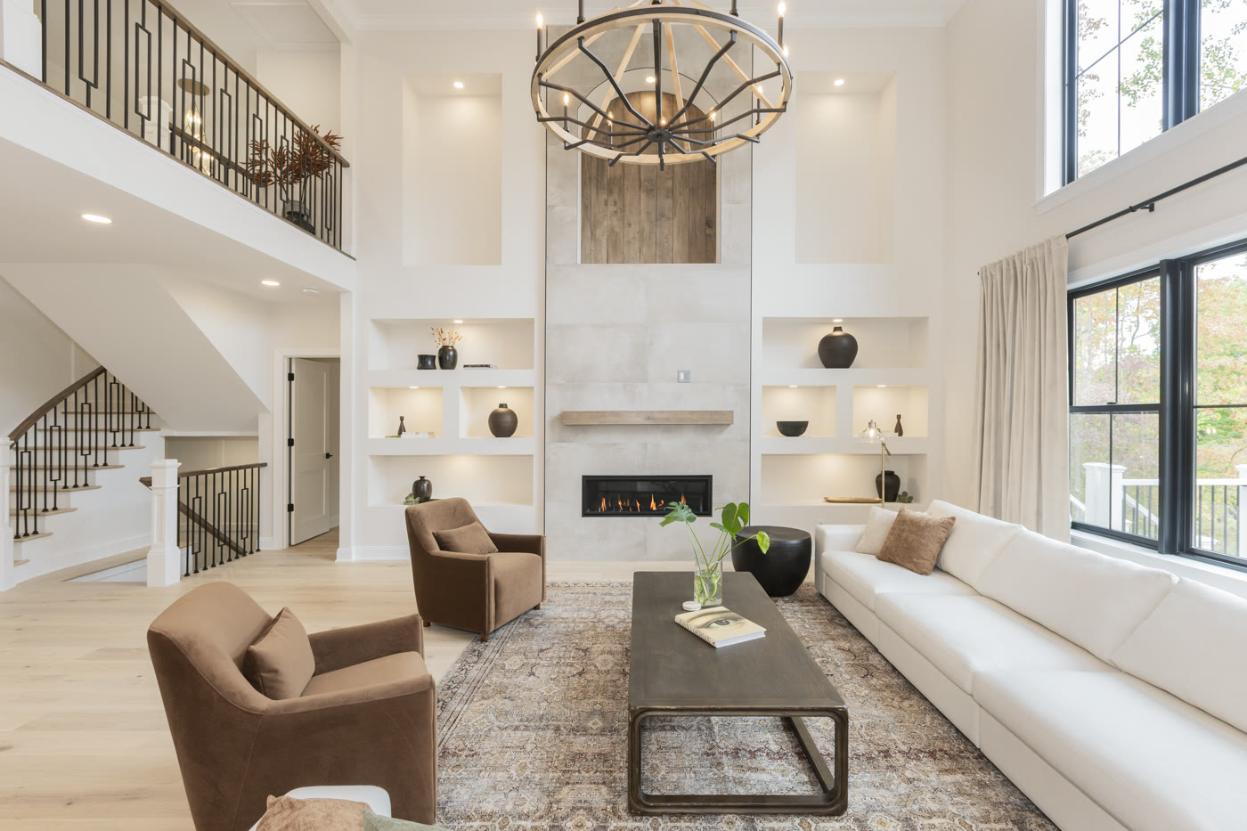Luxury staged living room with organic fireplace and built-in niches by Homes Aglow