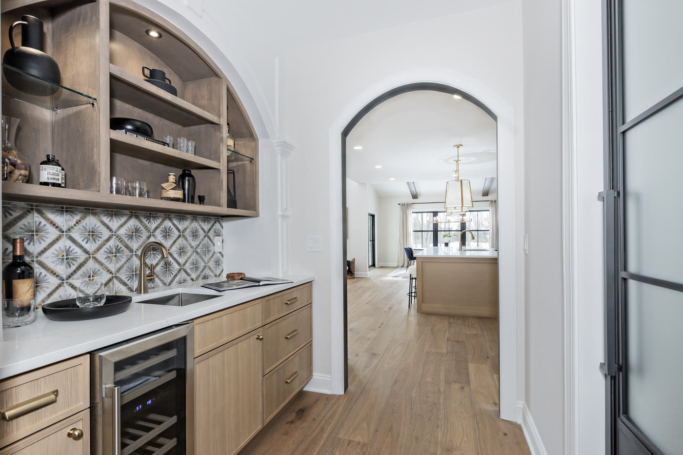 Luxury staged butler pantry with patterned tile and arched shelving by Homes Aglow