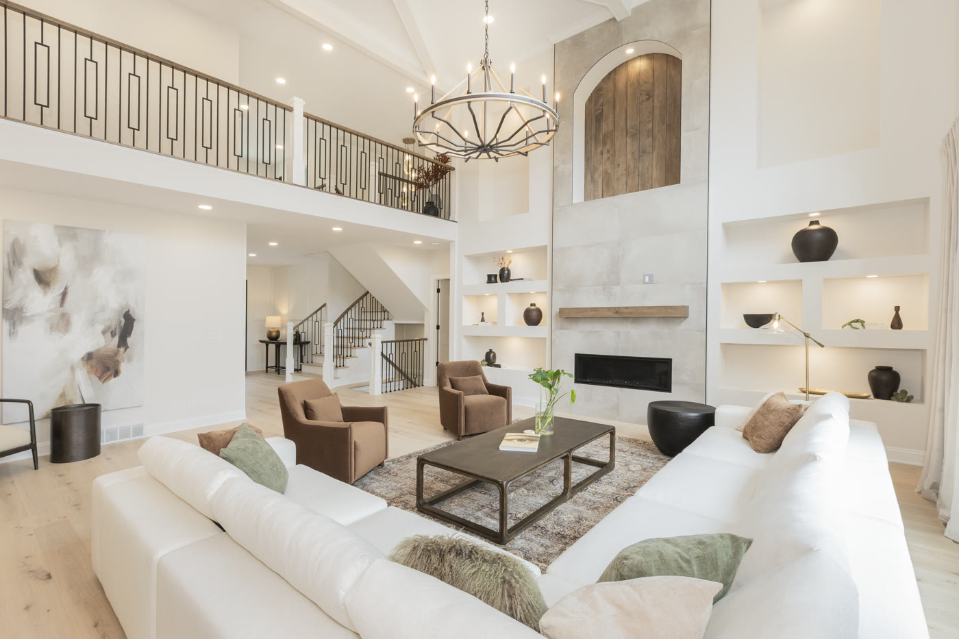 Luxury staged living room with concrete fireplace and earth tone design by Homes Aglow