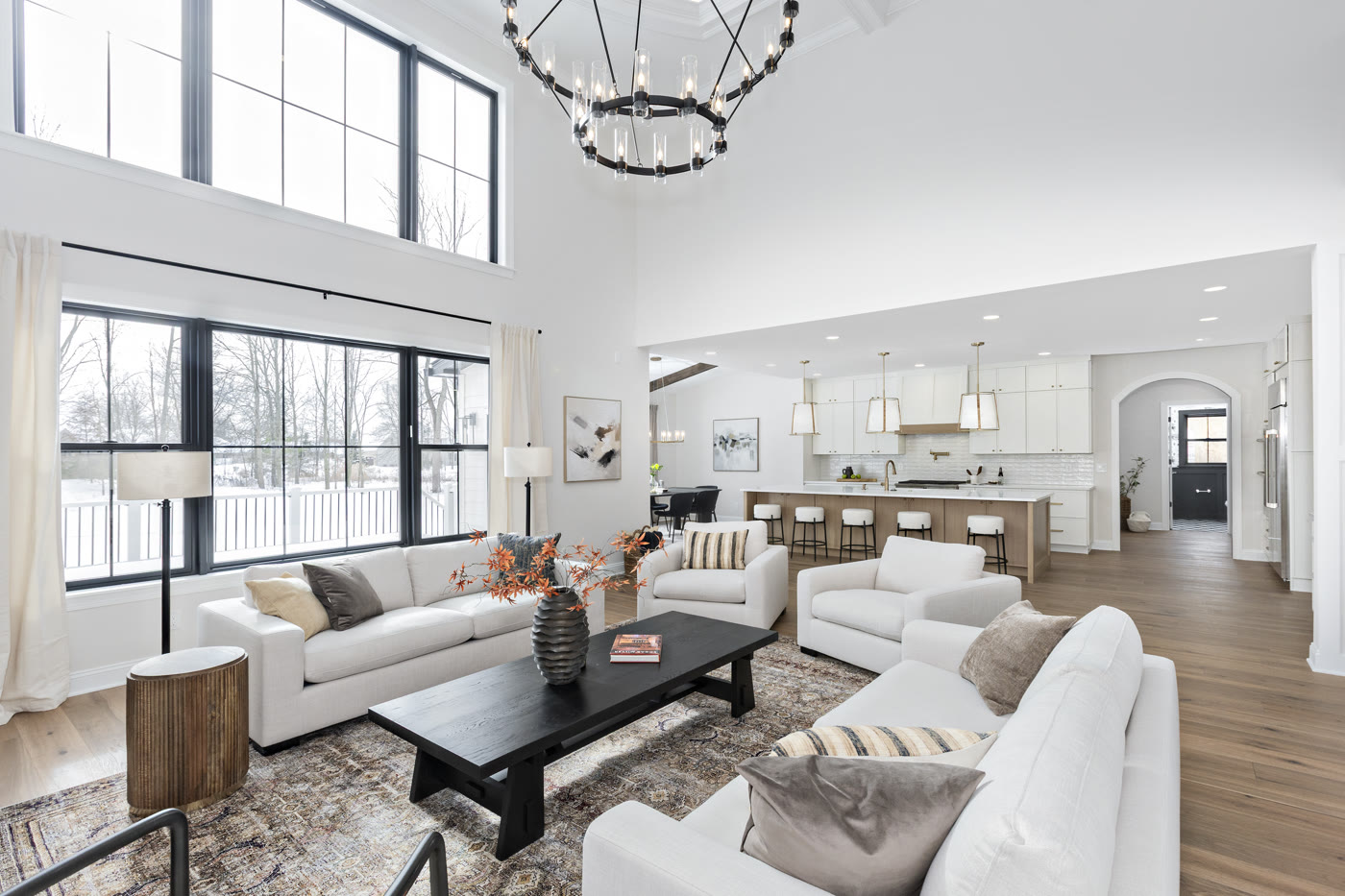 Open concept luxury staged great room with chandelier and kitchen by Homes Aglow